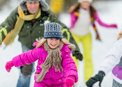 Happy child ice skates with family