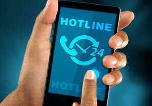 A cell phone with the word "hotline" is held in a person