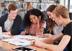 A group of teens laugh and study together