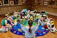 Librarian reads a story to stuffed animals